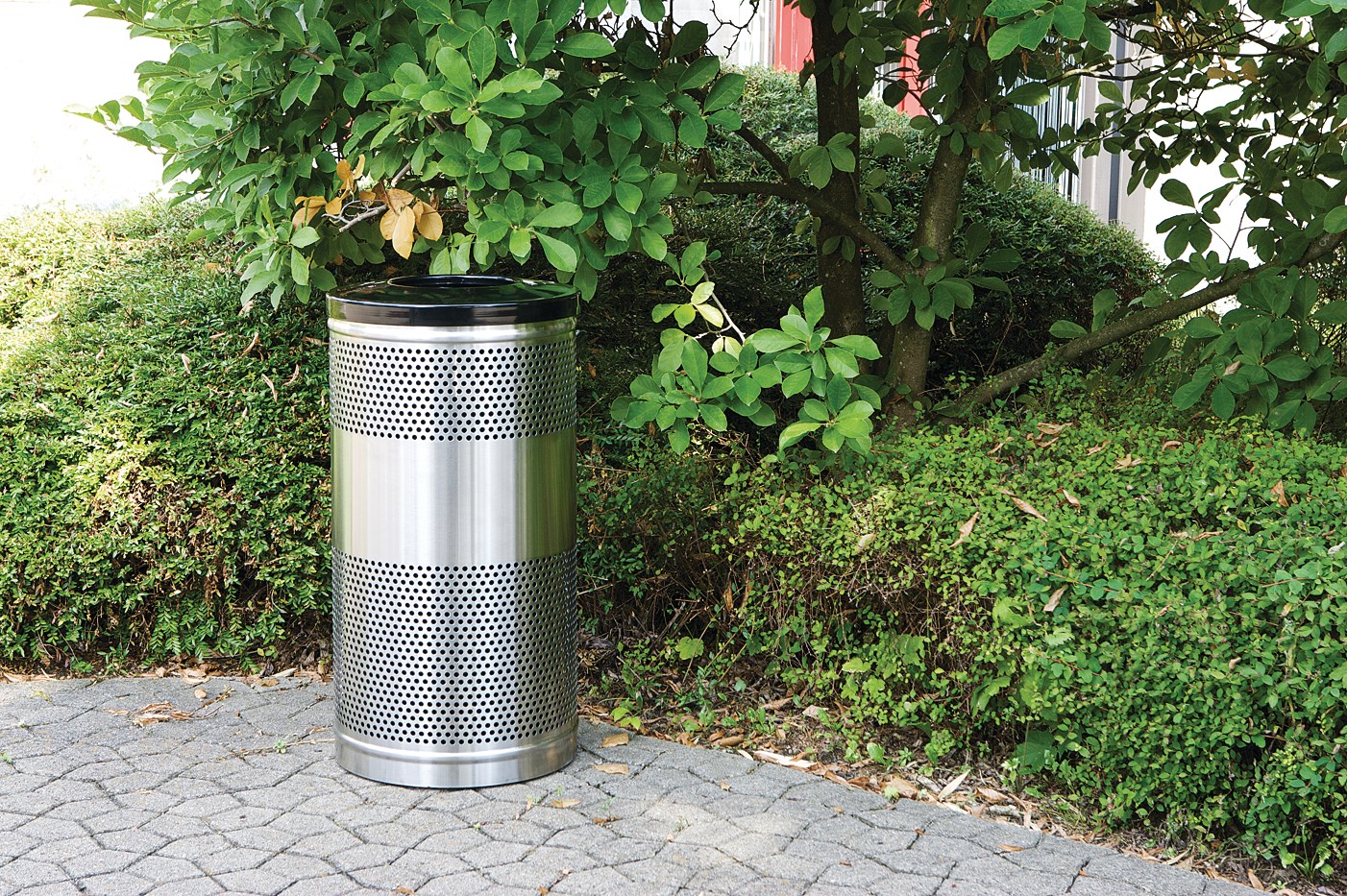 The heavy-duty Classics Decorative Waste Container has a perforated steel design for a clean and modern appearance. This container is a smart choice for high-traffic areas and can be used both outdoors and indoors.