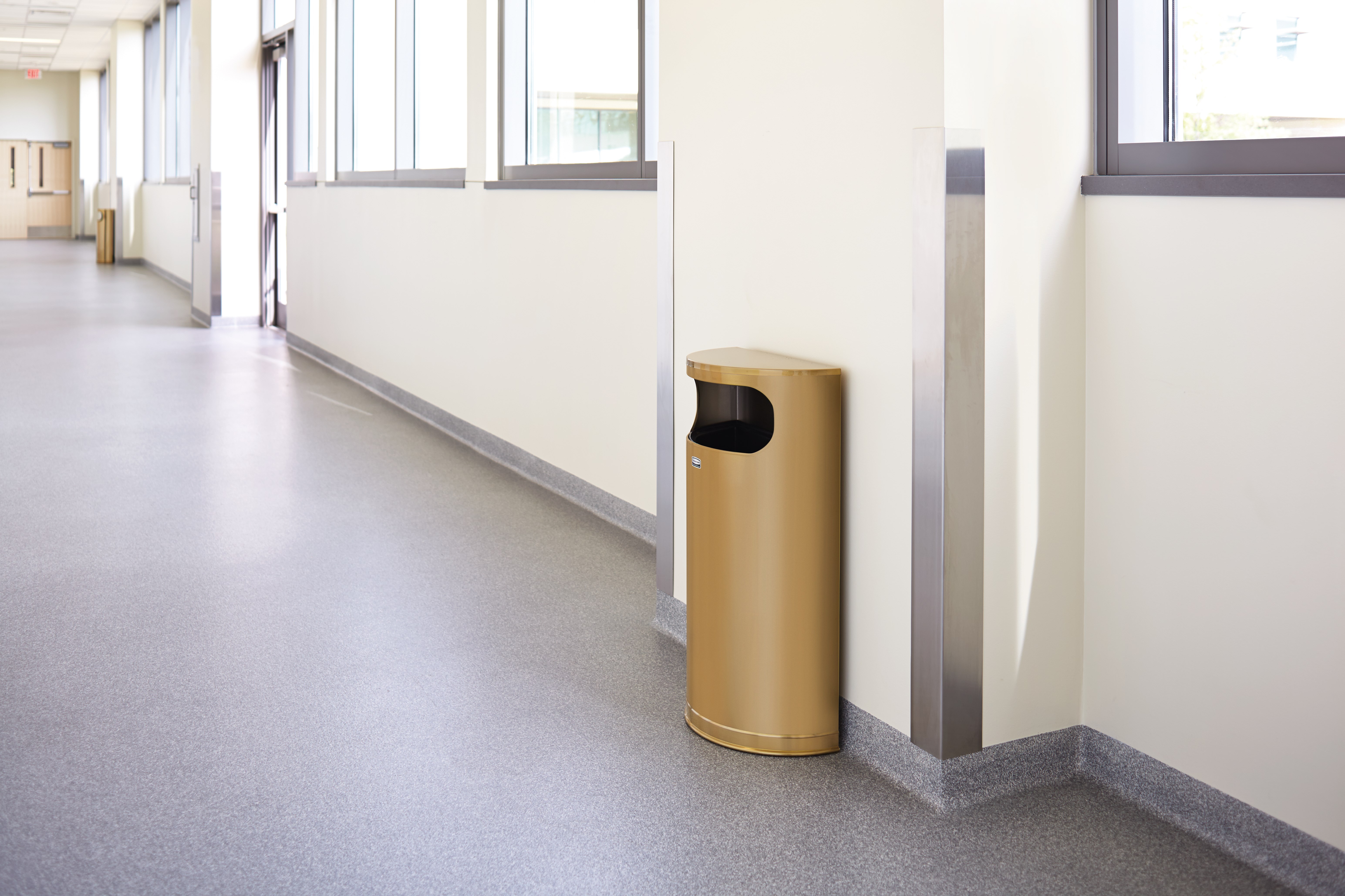 The Half Rounds Series indoor decorative waste container fits flush against walls to conserve space and reduce obstructions in high-traffic areas. The sleek and functional design of this receptacle blends seamlessly with upscale and modern indoor facilities.